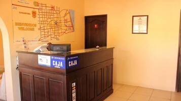 Mostrador de recepción con un mapa y una puerta al fondo.