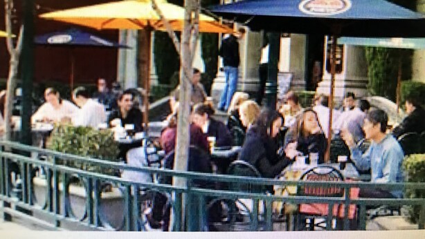An outdoor café with tables and chairs, surrounded by a railing. - SmartStay Melbourne (Windsor)