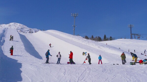 A ski slope with skiers and snowboarders.