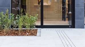 A hotel entrance with a modern glass facade and a sign reading "MEITETSU INN". - Meitetsu Inn Hamamatsucho (Tokyo)