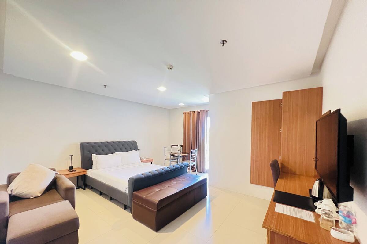 Une chambre d’hôtel moderne équipée d’un lit, d’un bureau, d’une chaise et d’un téléviseur.