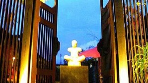 A traditional Japanese torii gate with a stone lantern in the center, set against a twilight sky. - Artist Place Trat (Trat)