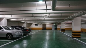 Eine mehrstöckige Tiefgarage mit grünen Böden und weißen Wänden.