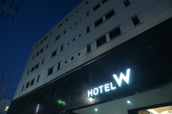 Ein Hotelgebäude mit einem großen 'HOTEL'-Schild an der Fassade.