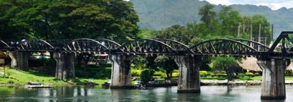 A bridge with a series of arches over a river, surrounded by greenery and hills in the background. - A and S Residence Kanchanaburi (Kanchanaburi)