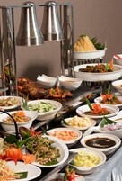 A buffet with various dishes, including seafood, salads, and a roasted meat centerpiece.