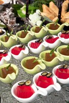 A dessert display with various shaped dishes containing jelly and garnishes.