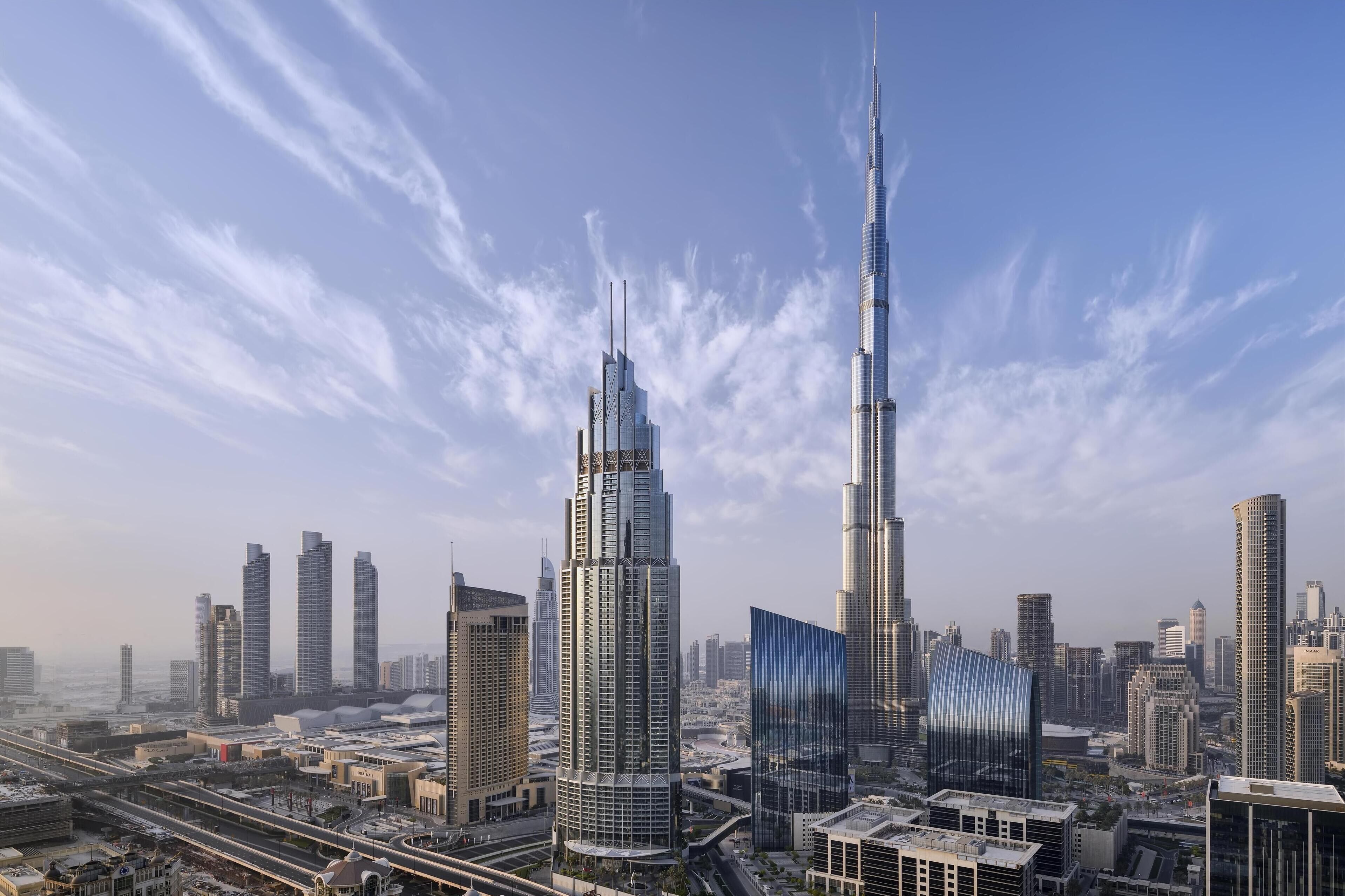 A cityscape with modern skyscrapers, including a prominent tower with a spire.