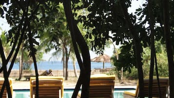 Una piscina al aire libre, sombrillas, tumbonas