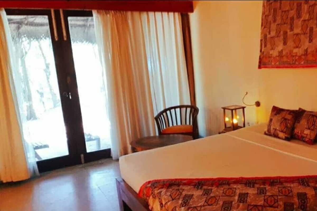 Ein Hotelzimmer mit einem Bett, einem Sessel, einem Tisch und einer Wandteppich.