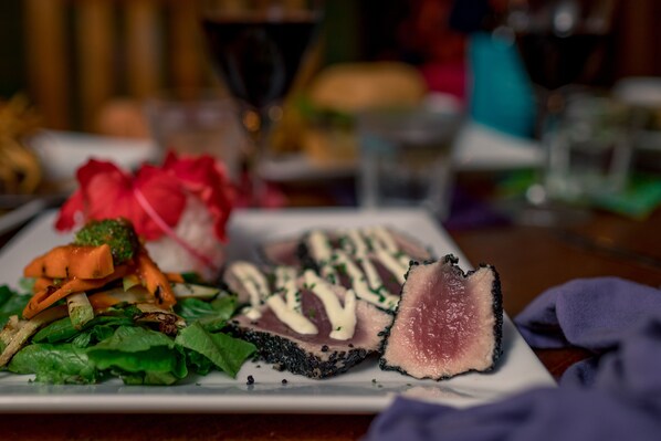 A plate of food with various vegetables and a slice of meat.