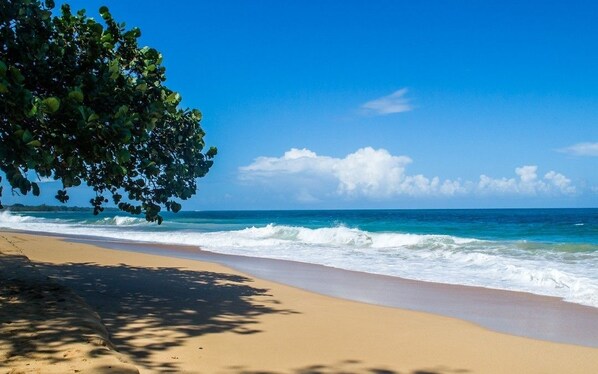 En la playa, arena blanca, sillas reclinables de playa, toallas de playa