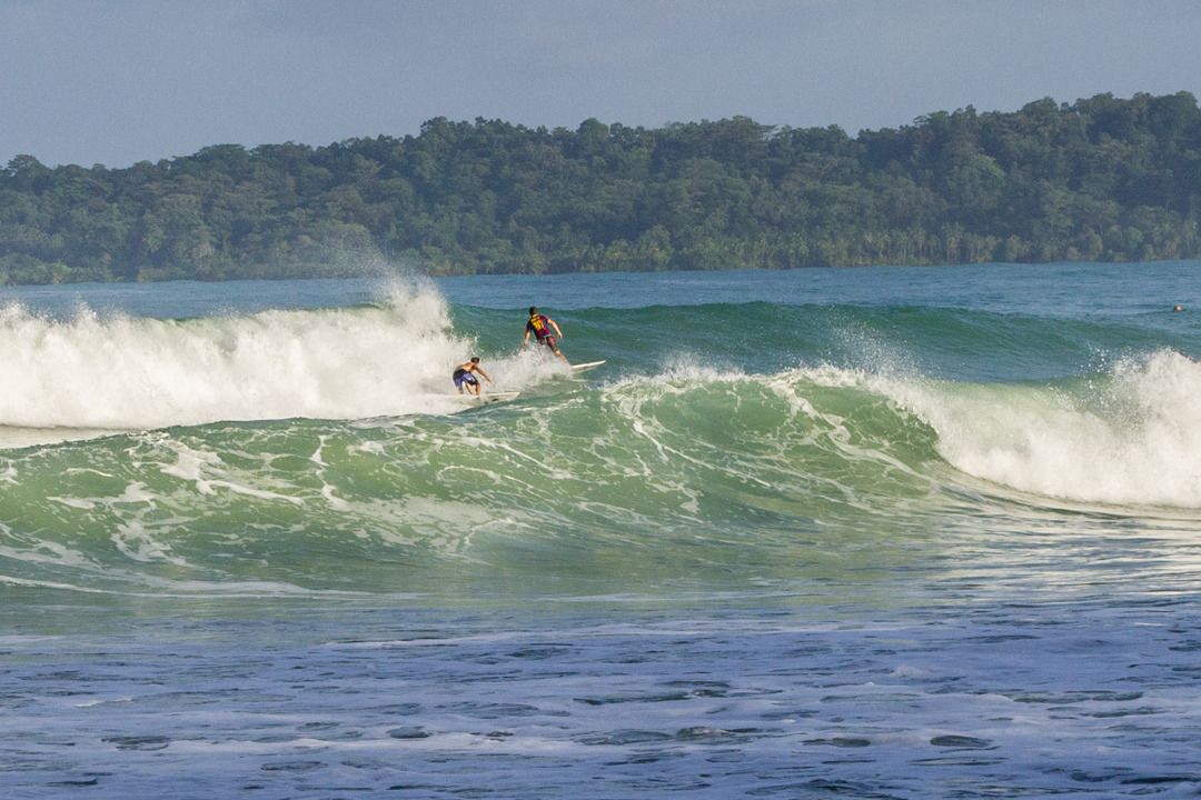 Una playa con surfistas cabalgando olas.