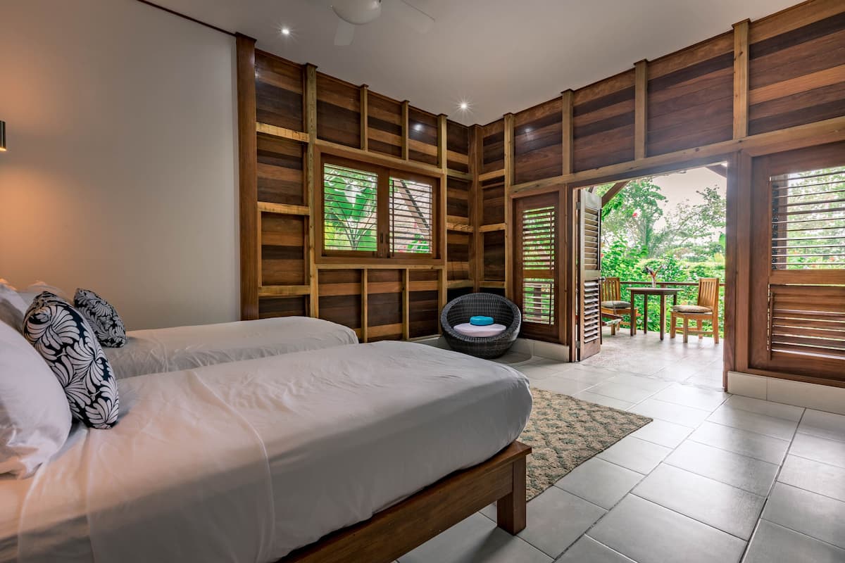 Une chambre avec un lit, une chaise et une vue sur l’extérieur.