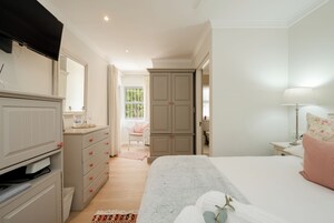 Un dormitorio con cama, cómoda y ventana con cortinas.