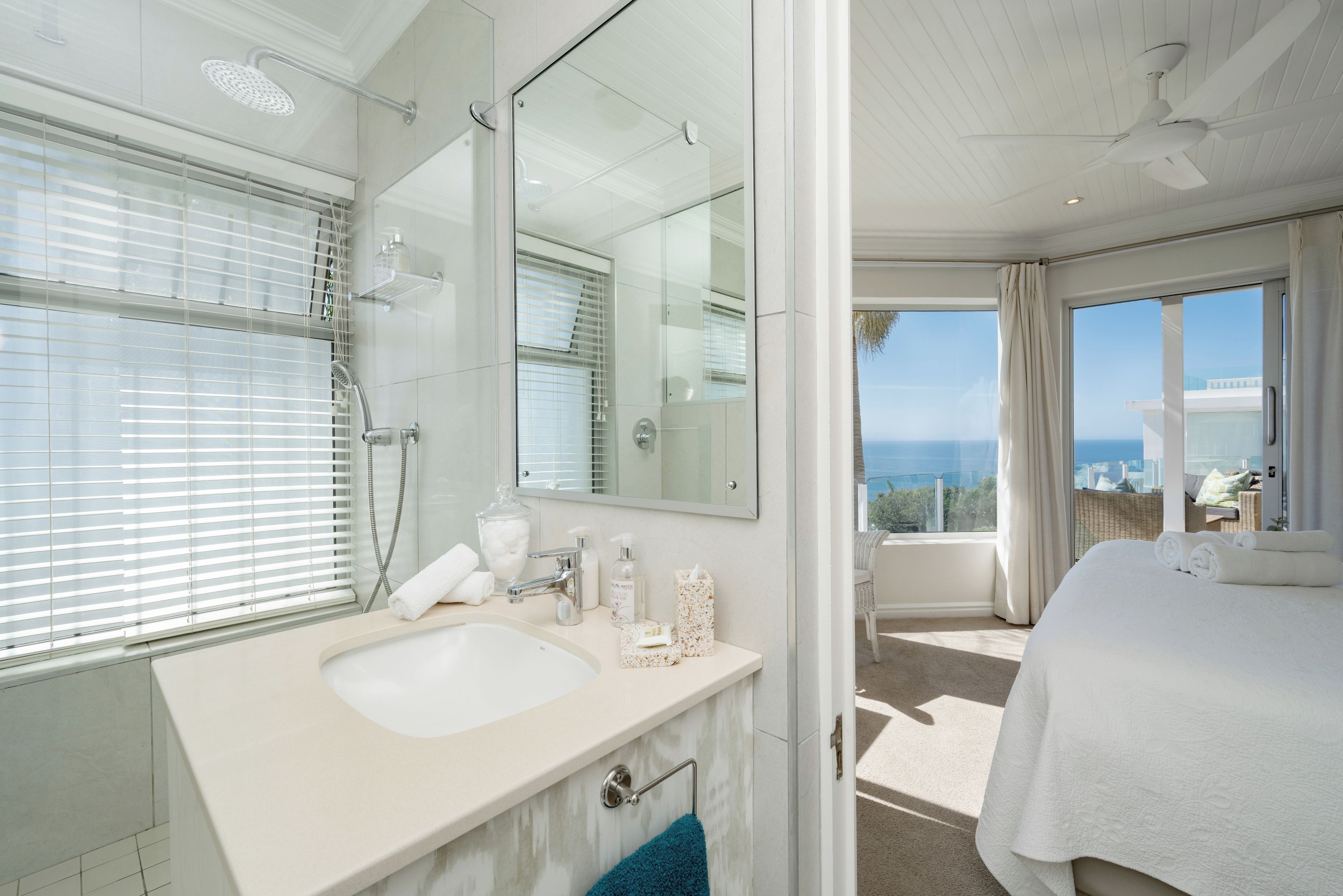 Een moderne badkamer met een grote spiegel, een bad en een douche.