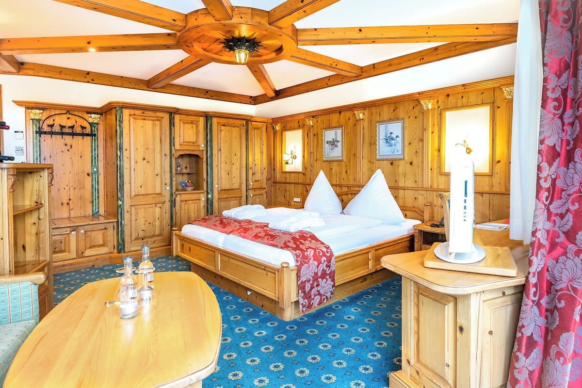 Een houten kamer met een bed, een tafel en een kast.