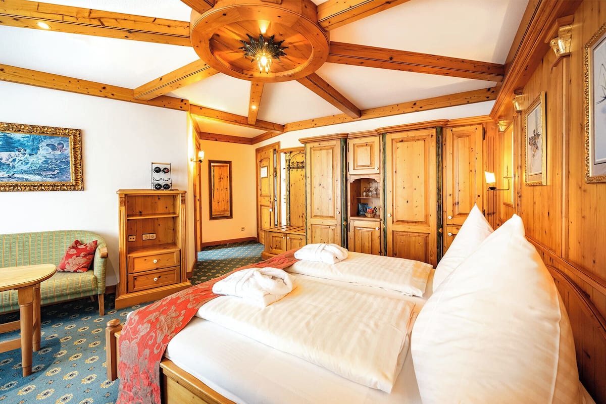 Een kamer van hout met een bed, een stoel en een tafel.