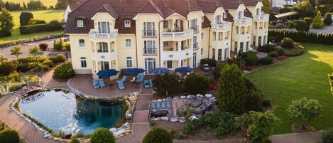 A large, multi-story building with a swimming pool and outdoor seating area.