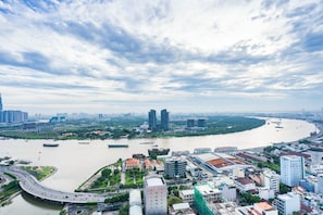 A cityscape with a river, modern buildings, and a bridge. - Sunny Saigon Apartments & Hotel (Ho Chi Minh City)