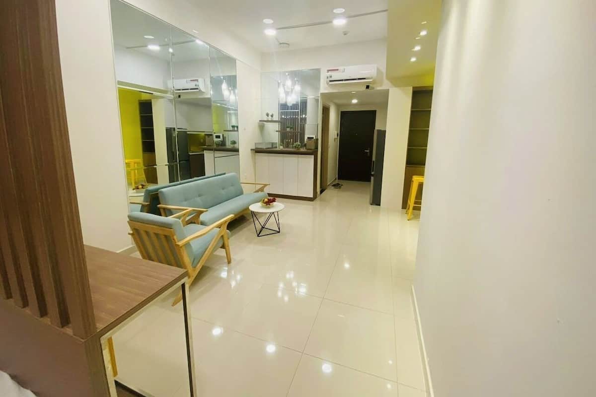 Una sala de estar moderna con un sofá, una mesa de centro y un comedor con mesa y sillas.
