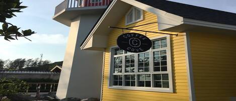 Un edificio amarillo con balcón y un letrero que dice "Coffee Cove".