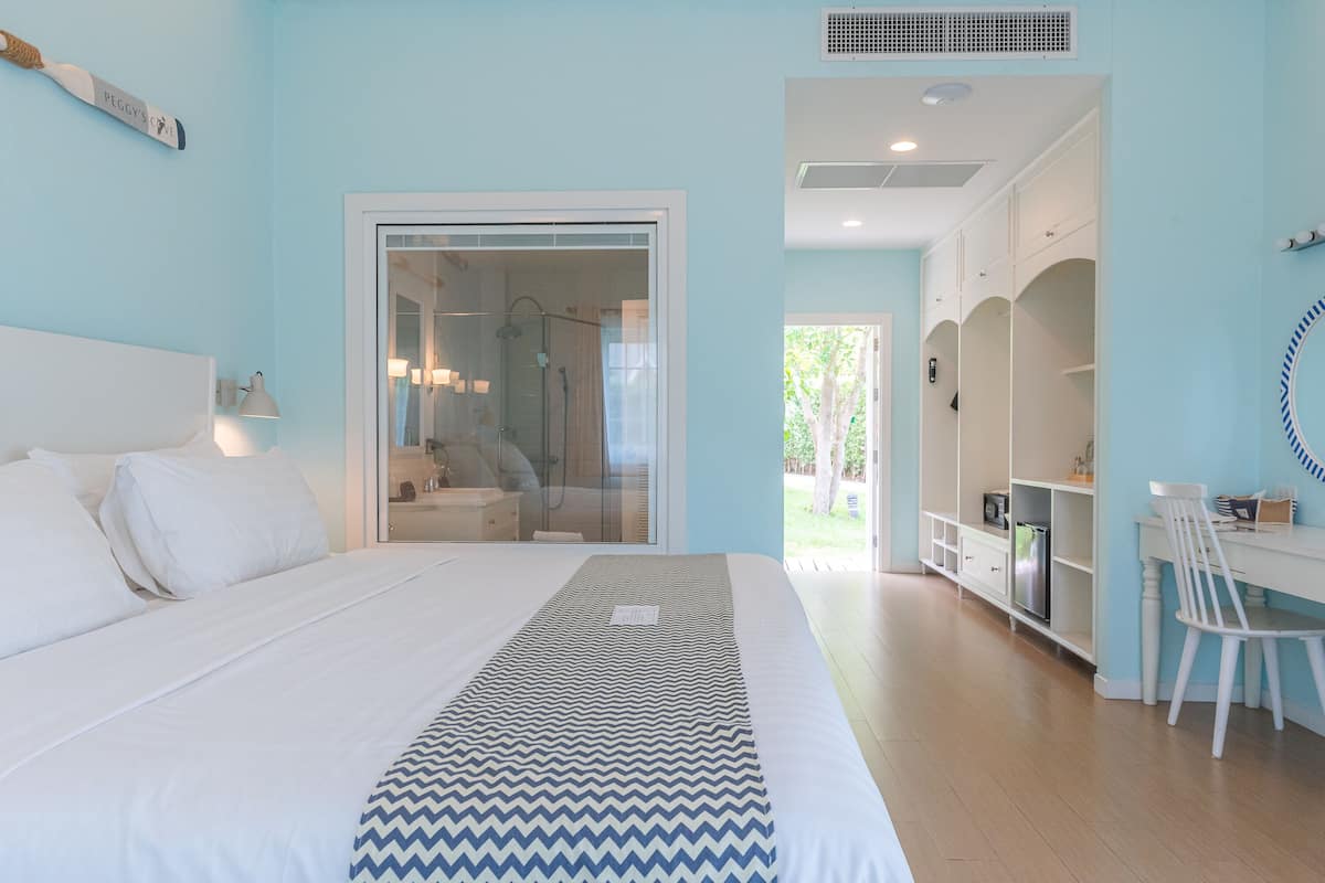 Une chambre comprenant un lit, un bureau et un espace douche.