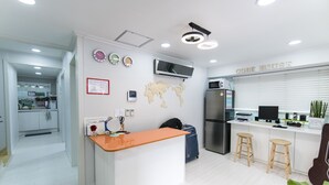 Uma cozinha moderna com uma ilha central, geladeira, micro-ondas e um mapa-múndi na parede.