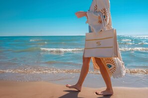 A person walking on a beach with a towel and a bag. - Side Sun Hotel - All Inclusive (Manavgat)