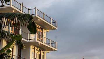 Un immeuble à plusieurs étages, doté de balcons et d’un toit rouge.
