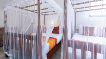 Una habitación con dos camas, cada una con dosel y almohadas.