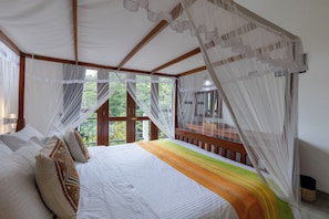 A room with a bed, a view of the outdoors, and a balcony.