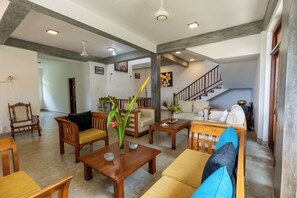A spacious living area with wooden furniture, a staircase, and a view of the interior.