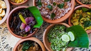 A variety of dishes served in terracotta bowls on a woven tablecloth. - Hanthana House (Kandy)