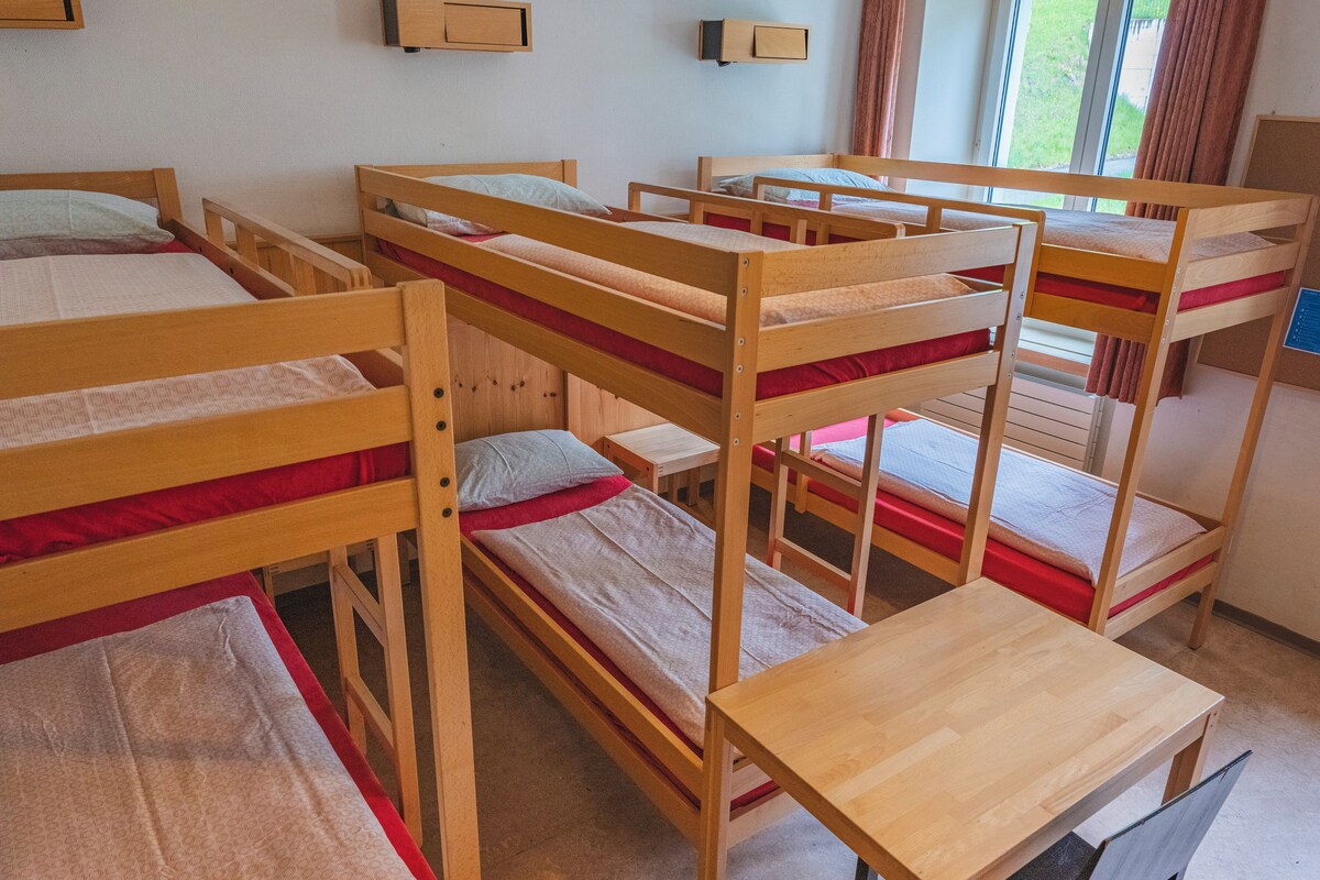 Un dormitorio con literas y una pequeña mesa de madera.