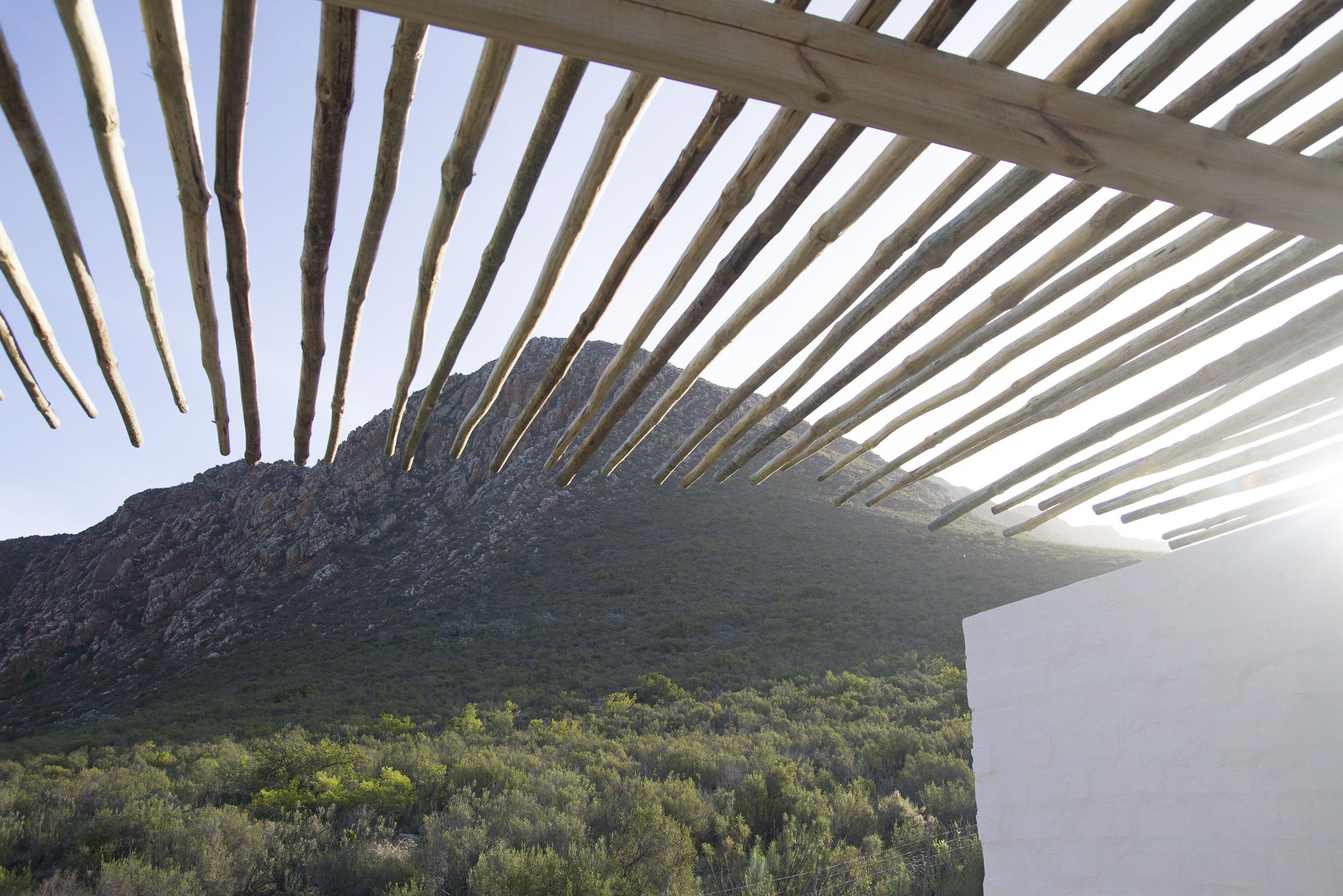 A view through a wooden structure with a mountain in the background.