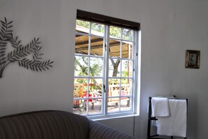 A room with a large window, a sofa, and a towel rack.