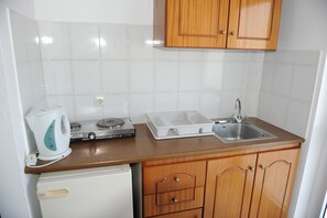Een koelkast met diepvriezer, een koffiezetapparaat/waterkoker