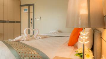 A hotel room with a bed, a nightstand, a lamp, and a door.