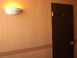 Enter a stylish room with a simple door and a wall-mounted light fixture.
