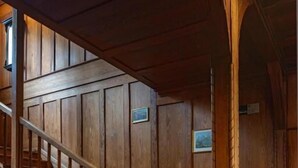 A wooden staircase with a handrail and a wooden wall with a picture frame.