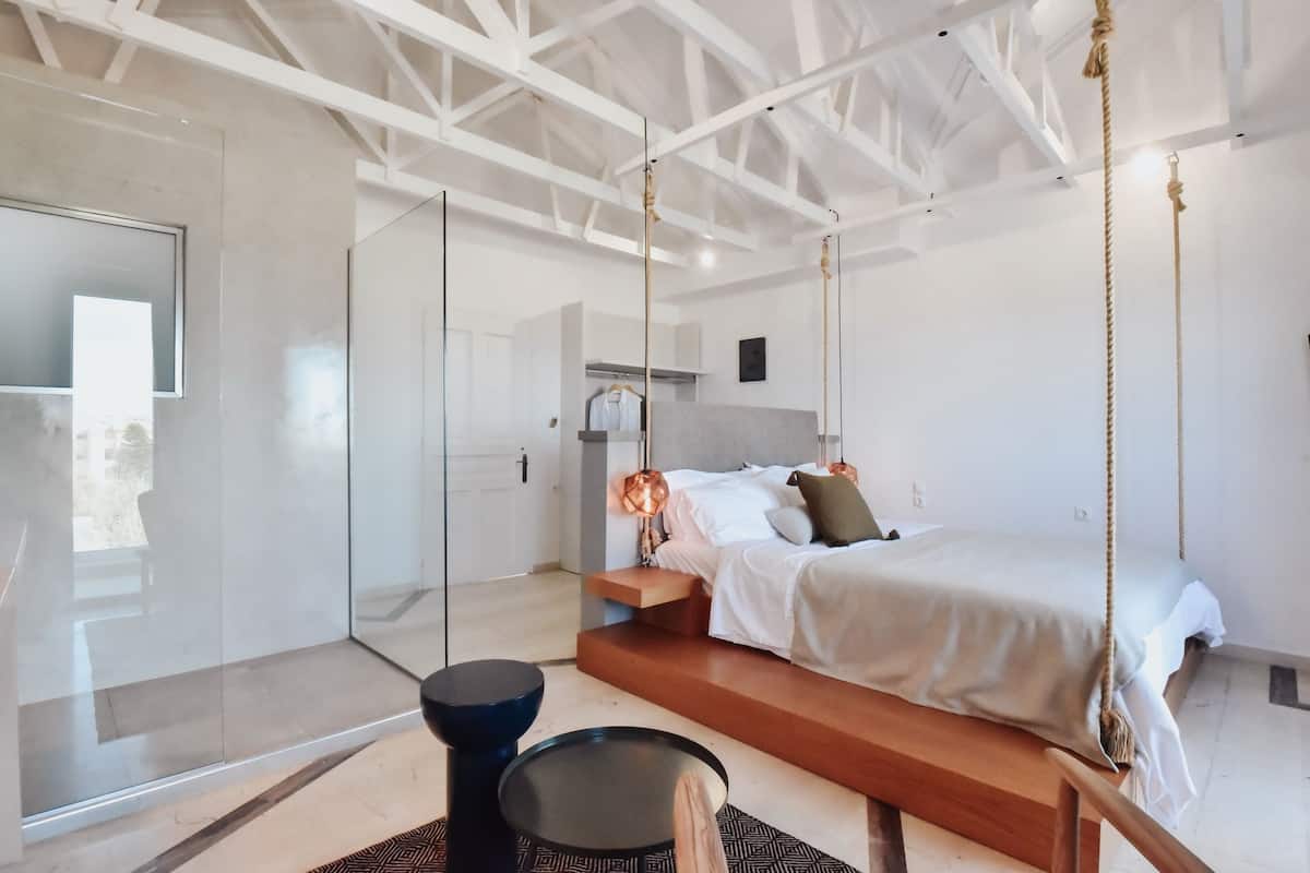 A modern bedroom with a suspended bed, a glass wardrobe, and a minimalist design.
