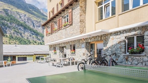 Un edificio de piedra con balcón, mobiliario exterior y bicicletas.