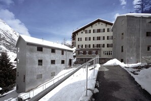 Un bâtiment doté de nombreuses fenêtres et un chemin enneigé menant à l’entrée.