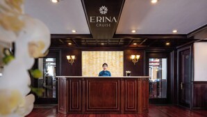 Una mesa de recepción con un letrero que dice "ERINA CRUISE" y una recepcionista.