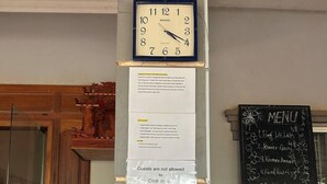 Une horloge, un menu et un panneau indiquant le mode de paiement dans un café.