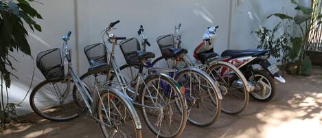 A row of bicycles parked against a wall.