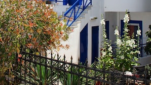 Ein weißes Gebäude mit blauen Akzenten, darunter Balkone und Treppenhäuser.