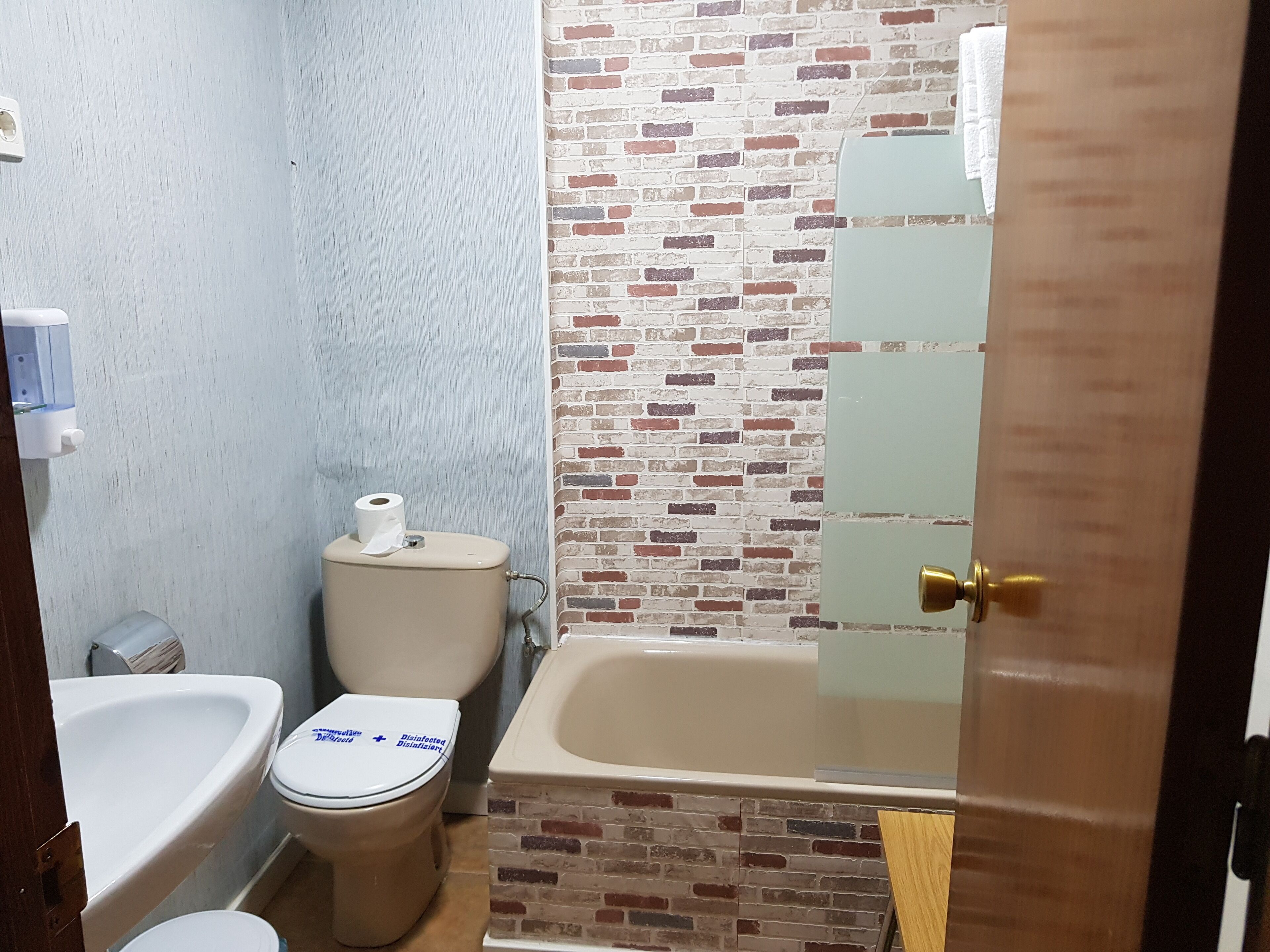 Un baño con inodoro, lavamanos y bañera.
