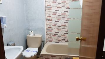 Un baño con inodoro, lavamanos y bañera.